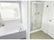 A bright bathroom featuring a soaking tub under a window and a glass-enclosed shower at 382 Winston Circle Cir, Canton, GA 30114