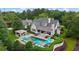 Aerial view of home showcasing in-ground pool, patio, and lush landscaping at 710 Cox Rd, Roswell, GA 30075