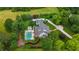 Stunning aerial view of estate home, in-ground pool, manicured lawns, mature trees and circular driveway at 710 Cox Rd, Roswell, GA 30075