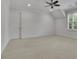 Spacious bedroom featuring neutral carpet, ceiling fan, and bright window at 710 Cox Rd, Roswell, GA 30075