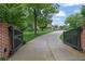 Grand gated entrance to a stunning property with a long driveway and meticulously manicured lawn at 710 Cox Rd, Roswell, GA 30075