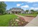 Stunning two-story home with a lush green lawn, beautiful landscaping, and a charming brick walkway at 710 Cox Rd, Roswell, GA 30075