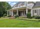 Charming front porch with columns and a swing, surrounded by lush landscaping and a well-manicured lawn at 710 Cox Rd, Roswell, GA 30075