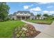 Traditional home with front lawn, manicured garden and walkway leading to covered porch at 710 Cox Rd, Roswell, GA 30075