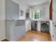 Bright laundry room with gray subway tile, dog bath, and modern washer and dryer at 710 Cox Rd, Roswell, GA 30075
