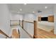 Open loft with light wood floors, barn door entertainment center, and white railing at 710 Cox Rd, Roswell, GA 30075