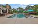 Relaxing backyard pool area with lounge chairs, umbrellas, and a covered patio for outdoor enjoyment at 710 Cox Rd, Roswell, GA 30075