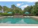 Inviting backyard pool with lounge chairs and lush landscaping, perfect for summertime relaxation and entertainment at 710 Cox Rd, Roswell, GA 30075