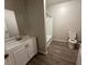Bathroom with modern flooring, toilet, sink with cabinet, and large mirror at 8 Hazel St, Porterdale, GA 30014
