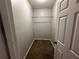 This walk-in closet features a carpeted floor and a bar for hanging clothes at 8 Hazel St, Porterdale, GA 30014