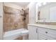 Bright bathroom featuring a shower over tub with tile surround and vanity with granite countertop at 8255 Habersham Waters Rd, Atlanta, GA 30350