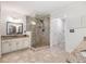 Bathroom featuring a glass-enclosed shower, double vanity, and neutral tile flooring for a spa-like experience at 8255 Habersham Waters Rd, Atlanta, GA 30350