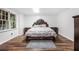 Bedroom featuring wood-look floors, neutral walls, and a luxurious bed at 8255 Habersham Waters Rd, Atlanta, GA 30350