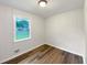 Well-lit bedroom with hardwood floors, white walls, and a bright window at 145 Washington St, Mcdonough, GA 30253