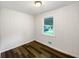 Cozy bedroom with hardwood floors, white walls, and a bright window at 145 Washington St, Mcdonough, GA 30253