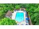Aerial view of the community pool surrounded by trees, lounge chairs, and umbrellas at 3650 Ashford Dunwoody Rd, Ne, #923 # 923, Atlanta, GA 30319