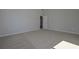 Well-lit bedroom with plush carpeting, neutral paint, and open doorway at 490 Charleston Pl, Villa Rica, GA 30180
