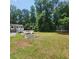 Spacious backyard featuring a fire pit, deck with white stairs, green grass, and a trampoline at 976 Bakers Bridge Rd, Douglasville, GA 30134
