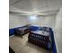 Basement bedroom with two twin beds, tile floors, and a drop ceiling at 976 Bakers Bridge Rd, Douglasville, GA 30134