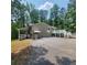 Charming home exterior featuring a covered entryway, large deck, and lush surrounding greenery at 976 Bakers Bridge Rd, Douglasville, GA 30134
