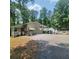 Charming home exterior showcasing a covered entryway, large deck, and lush surrounding greenery at 976 Bakers Bridge Rd, Douglasville, GA 30134