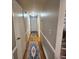A bright hallway with hardwood floors, decorative rugs, and access to various rooms at 976 Bakers Bridge Rd, Douglasville, GA 30134