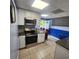 Modern kitchen featuring stainless steel appliances, white cabinets and tiled floor, and an eat-in area at 976 Bakers Bridge Rd, Douglasville, GA 30134