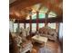 Living room with wood-paneled ceiling, ornate furniture set, and large windows at 976 Bakers Bridge Rd, Douglasville, GA 30134