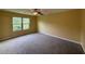 Large bedroom with plush carpet, ceiling fan and a sunny window overlooking the front yard at 102 Daisy Cir, Mcdonough, GA 30252