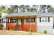 Charming ranch-style home featuring a spacious front porch with wooden deck and beige siding at 112 Village Ct, Woodstock, GA 30188
