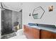 Modern bathroom with a glass enclosed shower, dark vanity with marble countertop, and hexagon mirror at 3146 Frontenac Ne Ct, Atlanta, GA 30319