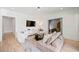 Living room area with hardwood floors, white walls, a TV, a sofa, and access to other rooms at 3146 Frontenac Ne Ct, Atlanta, GA 30319