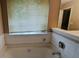 Bathroom featuring a built-in bathtub, tile surround, and a window at 3679 Seabass Rd, Decatur, GA 30034