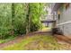 Exterior view showcasing the backyard with a patio deck and surrounding green trees at 6114 Leverett Dr, Lithonia, GA 30038