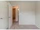 The bedroom offers neutral walls and carpet with an open door to additional rooms at 6114 Leverett Dr, Lithonia, GA 30038