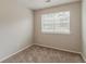 This bedroom features neutral walls and carpet with a window providing natural light at 6114 Leverett Dr, Lithonia, GA 30038