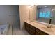 Bright bathroom features a double sink vanity, large mirror, and a relaxing soaking tub near the window at 6385 Southland Forest Dr, Stone Mountain, GA 30087