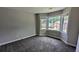 This bedroom features neutral walls and carpeting, and a large bay window to enjoy the neighborhood view at 6385 Southland Forest Dr, Stone Mountain, GA 30087
