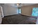 Spacious bedroom features carpet flooring, a ceiling fan, and large windows at 6385 Southland Forest Dr, Stone Mountain, GA 30087