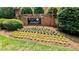 Inviting community entrance with manicured landscaping, flowers and a brick sign at 6385 Southland Forest Dr, Stone Mountain, GA 30087