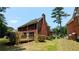 Traditional brick home with a spacious deck, a well-maintained lawn, and a brick chimney at 6385 Southland Forest Dr, Stone Mountain, GA 30087