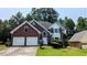 Charming two-story brick home with well-manicured lawn and attached two-car garage at 6385 Southland Forest Dr, Stone Mountain, GA 30087