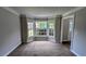 Bright living room with neutral carpeting and bay window, adjacent to other rooms at 6385 Southland Forest Dr, Stone Mountain, GA 30087