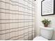 Bathroom features a shower with a gray and white striped curtain, and a white toilet at 220 Alcovy Reserve Way, Covington, GA 30014