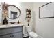 Half bath featuring round mirror, granite vanity, and unique decor at 220 Alcovy Reserve Way, Covington, GA 30014