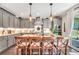 Eat-in kitchen with gray cabinets, stone kitchen island, stainless steel appliances, and modern pendant lights at 220 Alcovy Reserve Way, Covington, GA 30014