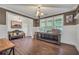 Bright living room showcasing hardwood floors, wainscoting, a large window, and a connecting entryway at 220 Alcovy Reserve Way, Covington, GA 30014