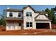 Unfinished two-story home showcasing window details, neutral siding, and an attached two car garage at 492 Charleston Pl, Villa Rica, GA 30180