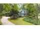Charming home with light blue siding, stone accents, and a welcoming front yard with mature trees at 1880 Doefield St, Canton, GA 30115