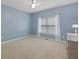 Bedroom featuring blue walls, a window dressed with sheer curtains, and neutral carpet at 2738 Riderwood Ne Ln, Marietta, GA 30062